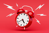 Ringing alarm clock on red background