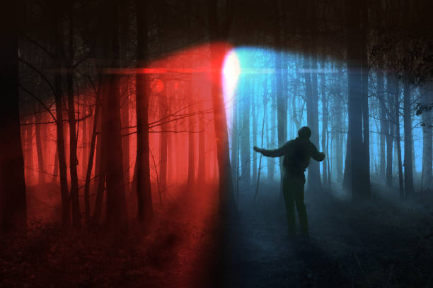 Dark woodland forest with a man spotted on the run under red and blue search lights. Criminal concept in winter trees landscape