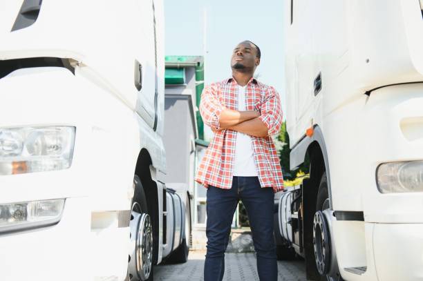 chauffeur de camion homme afro-américain musclé souriant, dans le transport et la livraison d’affaires de longue date - longtime photos et images de collection