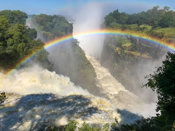 Victoria Falls,  Mosi-Oa-Tunya waterfall, Zimbabwe The iconic Victoria Falls,  aka Mosi-Oa-Tunya waterfall, view from the Zimbabwe side with a rainbow. lake kariba stock pictures, royalty-free photos & images