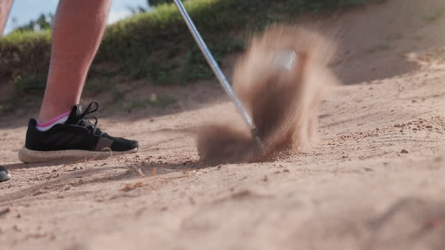 Pro golf player shot golf ball from sand bunker