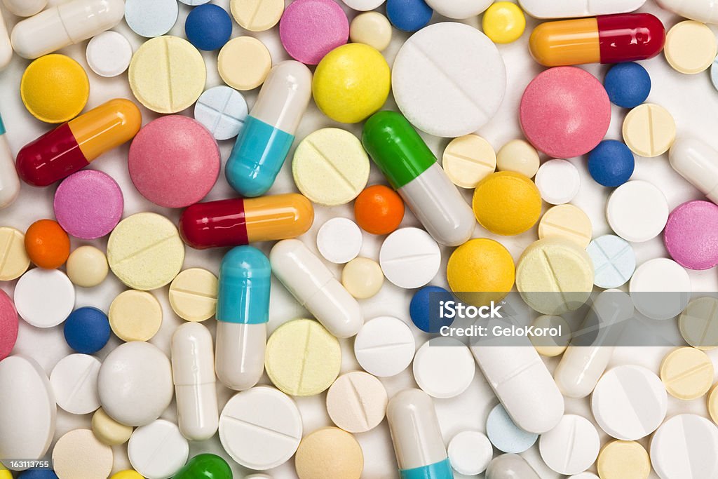 multi-colored tablets  II Macro shot of multi-colored tablets and capsules heap isolated on white background Capsule - Medicine Stock Photo