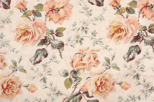 Antique floral fabric with clusters of pink flowers on a beige background..