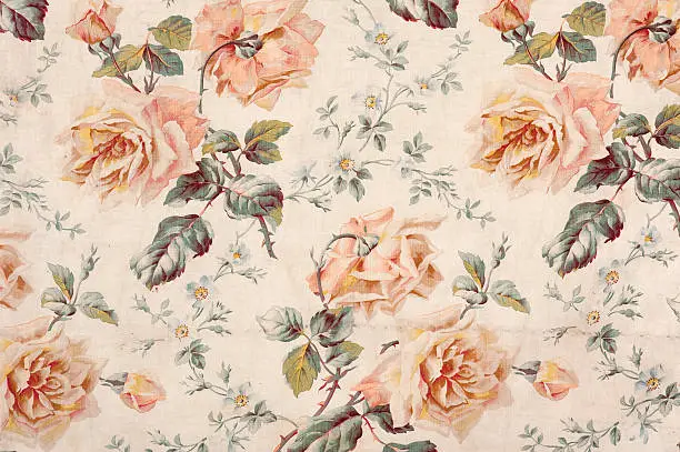 Antique floral fabric with clusters of pink flowers on a beige background..