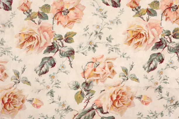 Antique floral fabric with clusters of pink flowers on a beige background..