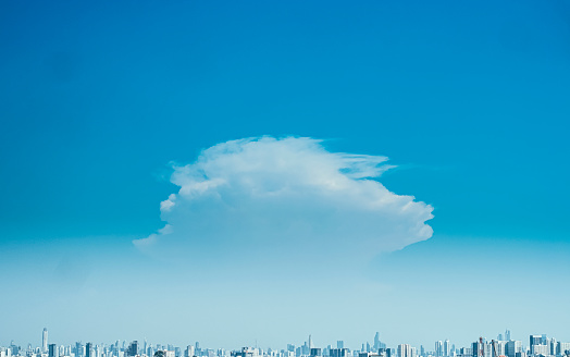 Panoramic view of city background blue sky with white huge single floating clouds against blue sky