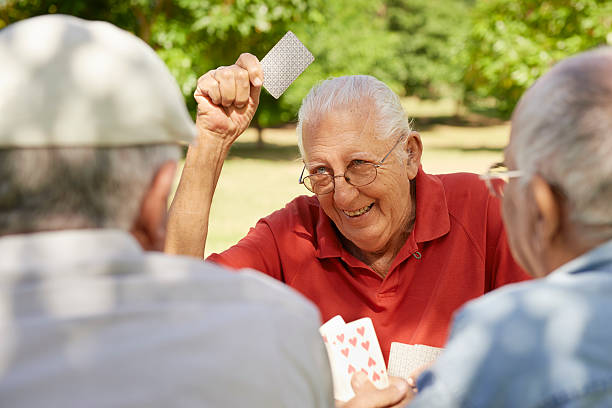 Active retired people, three senior men playing chess at park