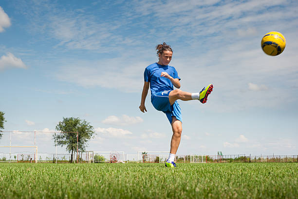 frau treten fußball-spielball - soccer shoe soccer player kicking soccer field stock-fotos und bilder