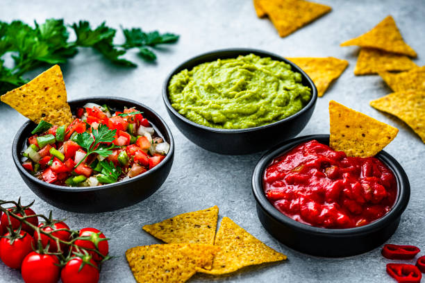 Mexican food: salsa sauce, guacamole and pico de gallo with nacho chips stock photo