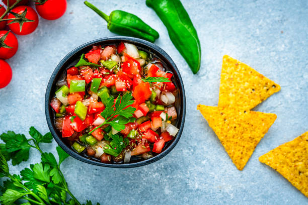 istock Mexican food: salsa pico de gallo and nacho chips shot from above on gray table 1631221206