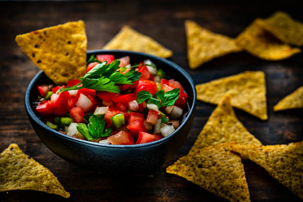 istock Tex-mex food: salsa pico de gallo and nacho chips shot on dark wooden table 1631221212