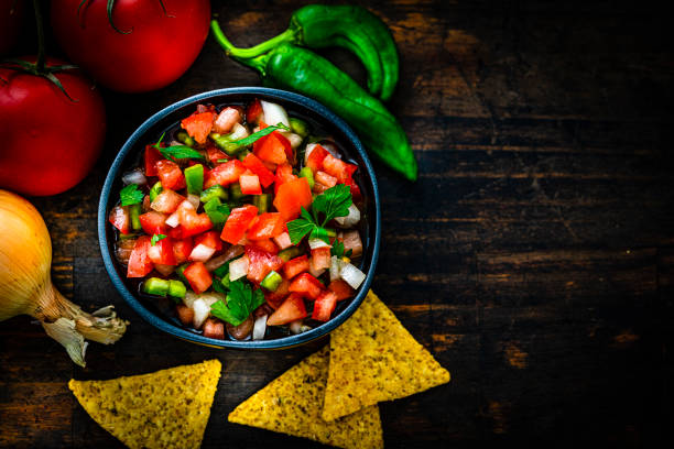 istock Tex-mex food: salsa pico de gallo, ingredients and nacho chips shot from above with copy space 1631221231