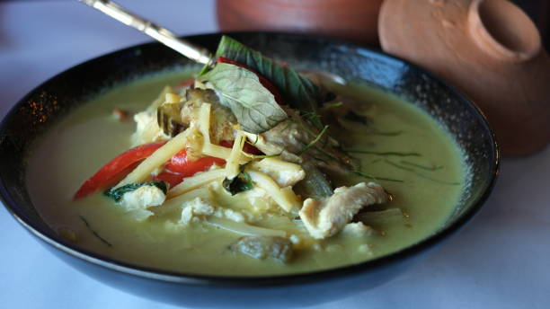 istock Thai chicken green curry on a black plate on a table. 1631223912
