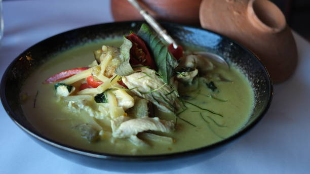 istock Thai chicken green curry on a black plate on a table. 1631224428