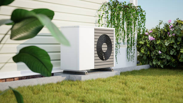 Photorealistic 3d render of a fictitious air source heat pump mounted to a concrete base with vibration dampers on the outside of a house. Rose bush, ivy and strelitzia in the garden. stock photo