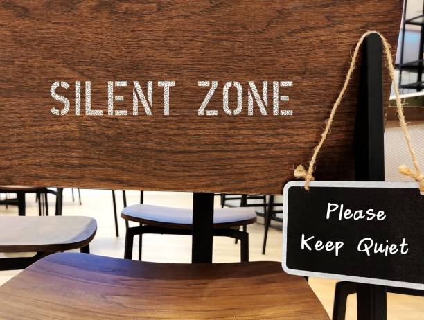 istock Chalkboard with handwritten PLEASE KEEP QUIET hang on Library chair  SILENT ZONE, warning sign in place where silence is needed to remind visitor in library and studying areas to keep noise level down 1631254036