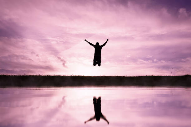 istock man jumping over a pond with a sunset background 1631260735