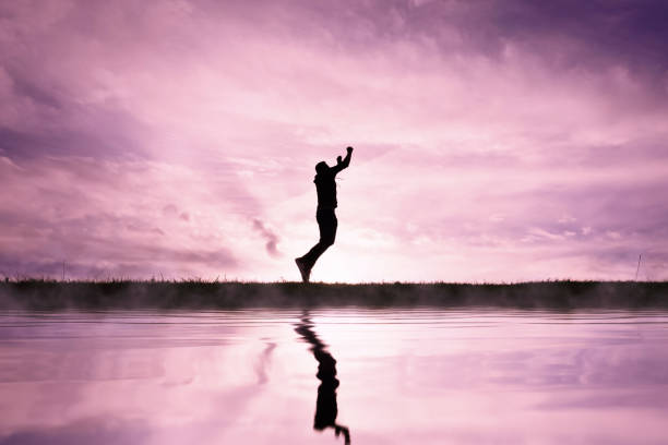 istock man jumping over a pond with a sunset background 1631260738