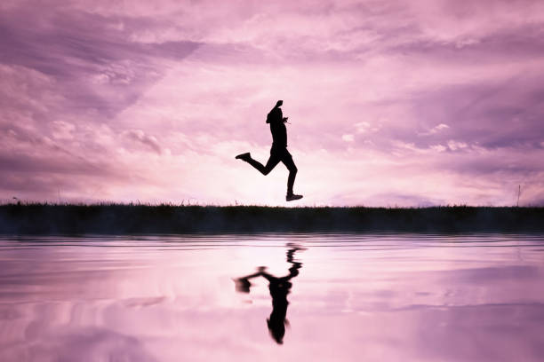 istock man jumping over a pond with a sunset background 1631260740