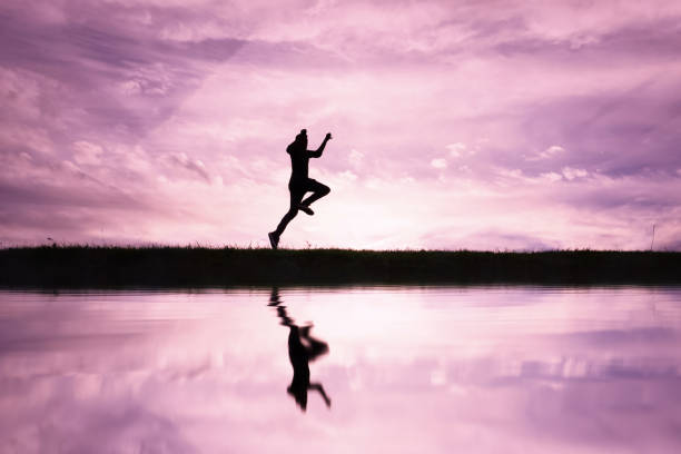 istock man jumping over a pond with a sunset background 1631260741