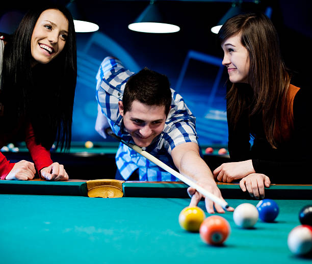 istock Young, happy friends playing billiards 163126079