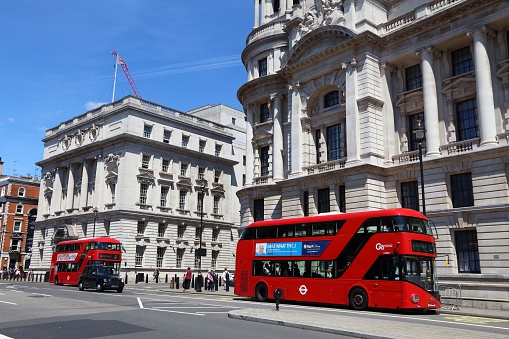 People ride New Routemaster bus in Whitehall, London. The hybrid diesel-electric bus is a new, modern version of iconic double decker.