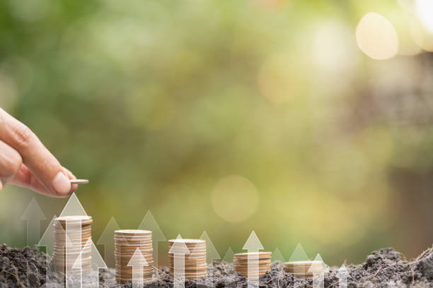 istock Save money target, success goals and investment growth concept. Stack coins on ground with white arrows rising on green nature background. Financial and business, Management money retire, tax 1631311975
