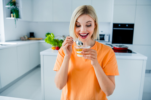 Photo of positive cheerful lady in kitchen room enjoy healthy dessert breakfast eating.