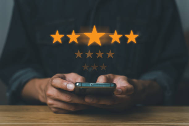 istock Virtual image scenario for evaluating customer satisfaction levels with mobile system. Ratings, reviews, survey responses. very happy, information. Man using mobile phone on wood desk in office 1631319884