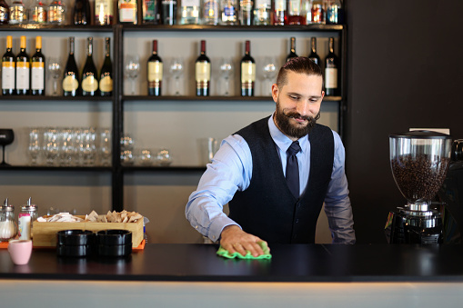 Young male bartender working in a bar. About 25 years old, Caucasian man.