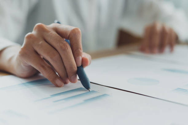 istock Professional businesswoman working on documents report show chart and graph with computer laptop at corporate office. Pen pointing data profit paperwork. Planing marketing, statistic analysis, concept 1631323705