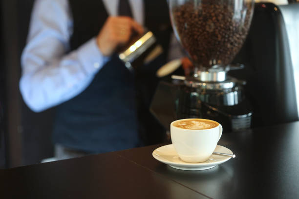 Young male bartender making cappuccino or espresso coffee in a bar. Unrecognizable Caucasian man.
