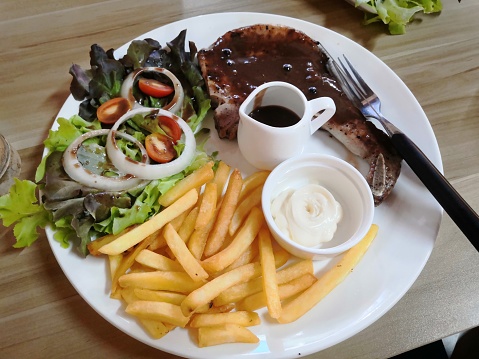 Pork Rib Steak with French Fries and Vegetables with Creamy Sauce