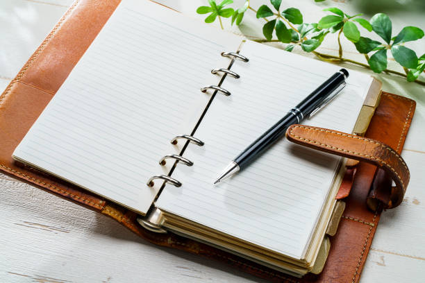istock Ring bound planner and pen on wooden table 1631334049