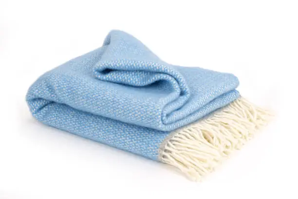 Soft en warm light blue wool blanket isolated on white background