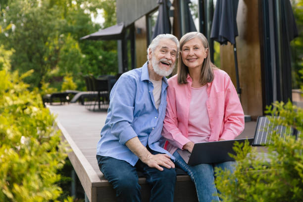 istock Man and woman sitting on house porch with solar panel using notebook. 1631345556