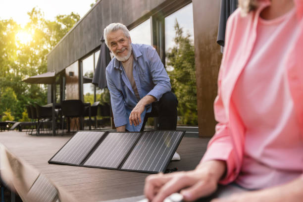 istock Mature couple using laptop in front of solar panels. 1631348338