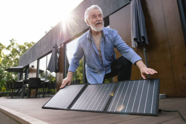 istock Mature man with solar panel on house porch. 1631348348
