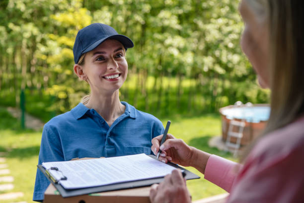 istock Courier delivering parcel, customer signs the delivery documents. 1631348376