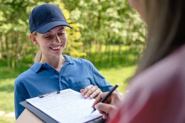 istock Courier delivering parcel, customer signs the delivery documents. 1631348378