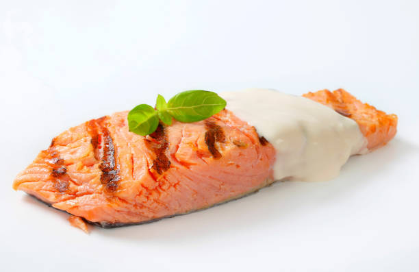 Salmon steak with mayonnaise dressing isolated on white