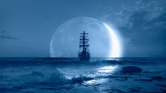 Sailing old ship in a storm sea with crescent moon stormy clouds in the background