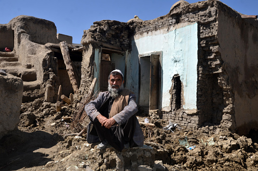 An old man siting in his destroyed house. He was so unhappy of what happened. A hard flood destroyed his house, assets, killed their livelyhoods and savings in Logar province of Afghanistan in 2022