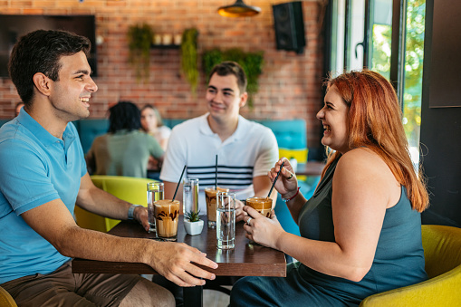 Young group of friends relaxing in a café, drinking coffee.