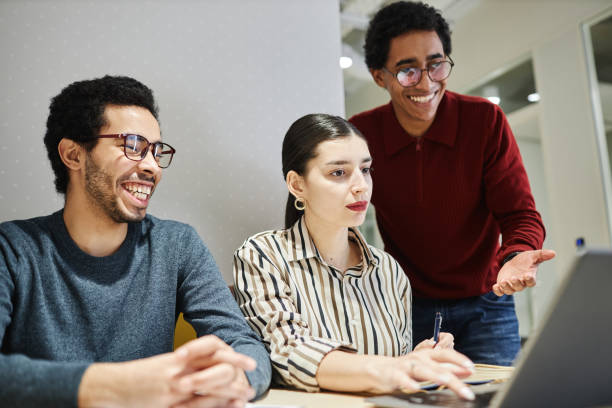 istock Group of three cheerful Middle Eastern business people using laptop 1631428672