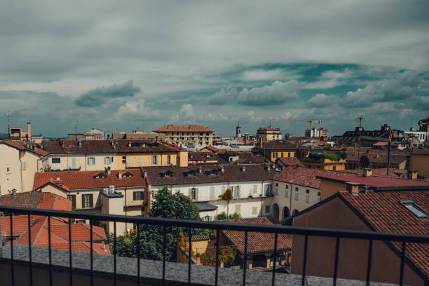 Piedmont small city rooftops and dramatic cloudy sky, Italy