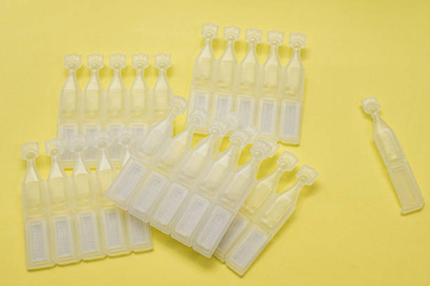 Disposable eye drops isolated on yellow background stock photo