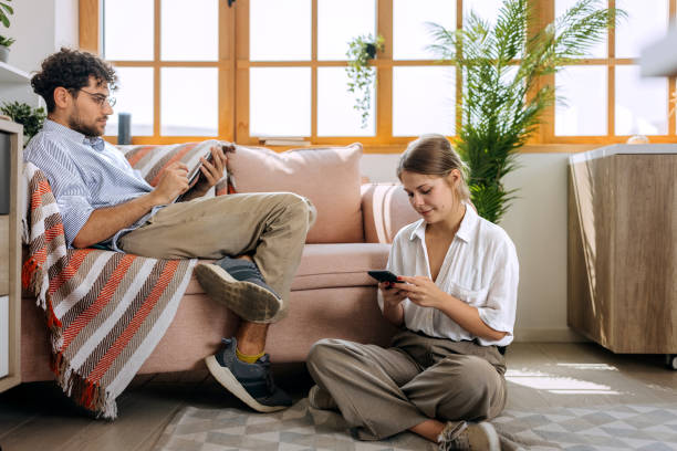 istock Couple using their own devices at home 1631434121