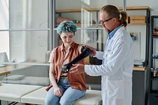 Portrait of young woman with colored hair smiling during prosthetic fitting in orthology clinic, copy space