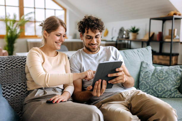 istock Young smiling couple using digital tablet at home 1631439754